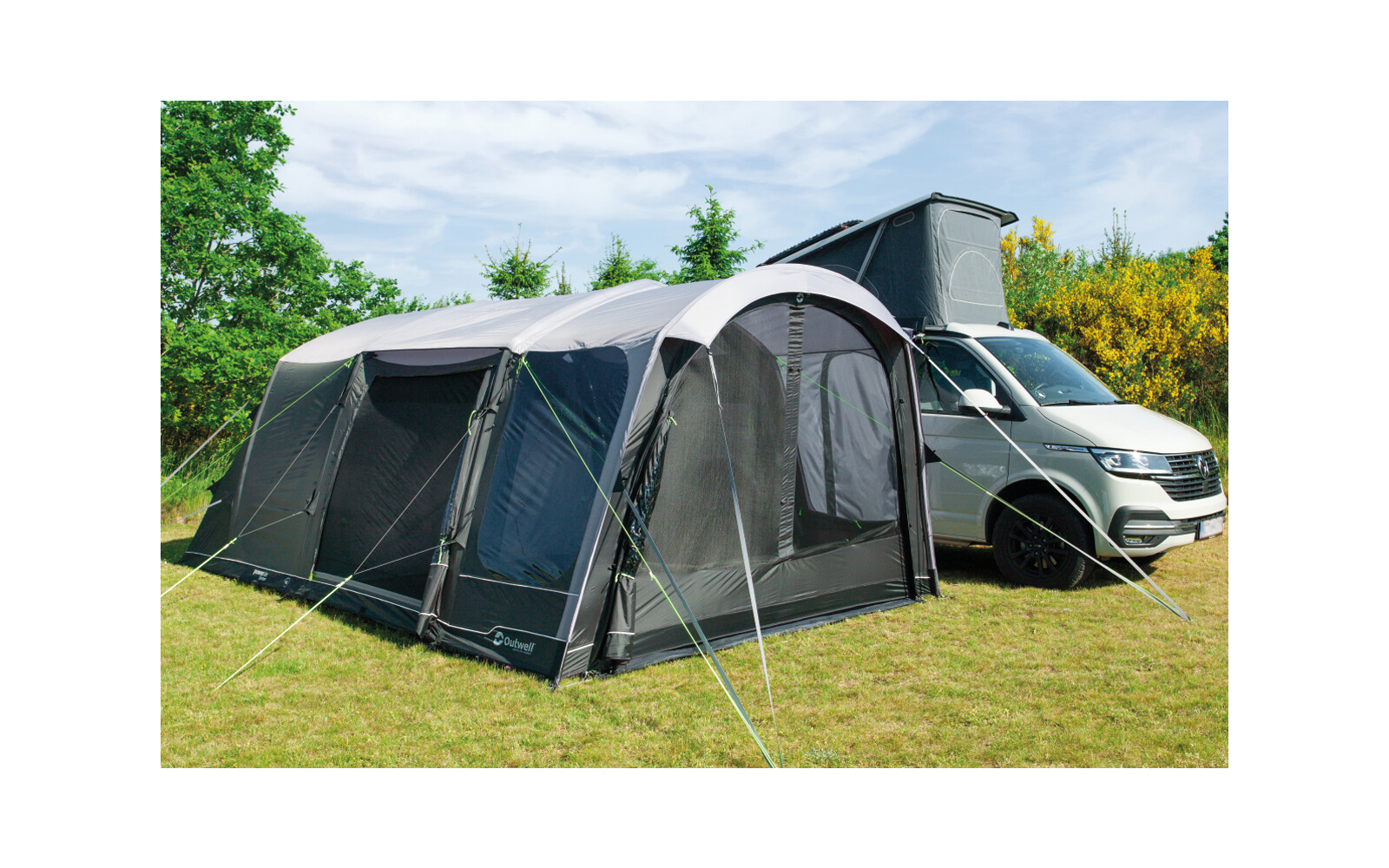 Tent with attached awning next to a white car on a grassy field