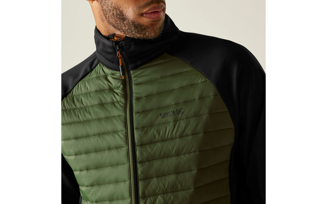 Ein Mann trägt eine grüne, gesteppte Jacke mit schwarzem Kragen und Schultern