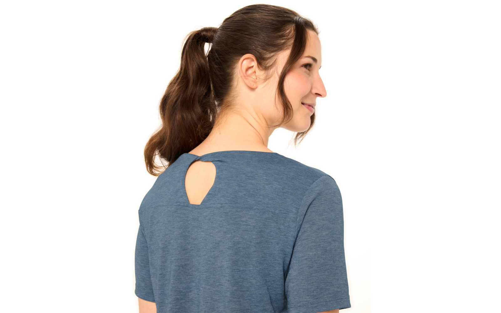 Person mit braunem Pferdeschwanz, von hinten und im rechten Profil sichtbar, trägt blaues kurzärmeliges Oberteil mit kleiner tropfenförmiger Öffnung am Nacken, weißer Hintergrund