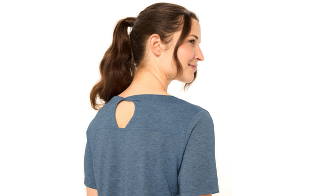 Person mit braunem Pferdeschwanz, von hinten und im rechten Profil sichtbar, trägt blaues kurzärmeliges Oberteil mit kleiner tropfenförmiger Öffnung am Nacken, weißer Hintergrund