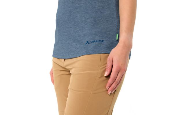 Teilansicht einer Person von Taille bis Oberschenkel, blaues T-Shirt mit VAUDE-Logo am Saum, beige Hose, rechte Hand an der Seite