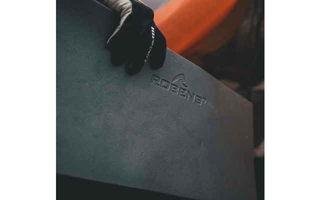 Hand met zwarte handschoen houdt een grijs lederen voorwerp met reliëf vast