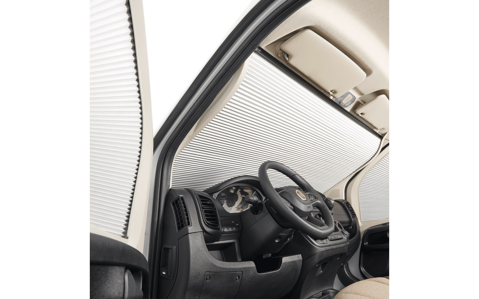 Vista interna lato guida di un veicolo con volante, cruscotto, quadro strumenti e un parasole argentato ripiegato che copre il parabrezza e il finestrino laterale