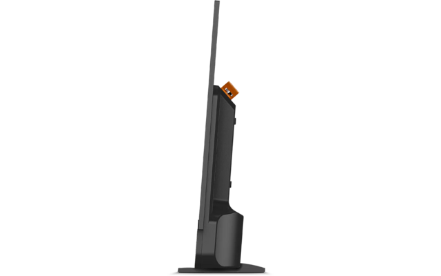 Vista laterale di uno schermo piatto nero su un supporto con base rettangolare, retro visibile con canalina per cavi nera e clip arancione