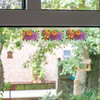 Bunte Papierblumen hängen an einer Fensterscheibe