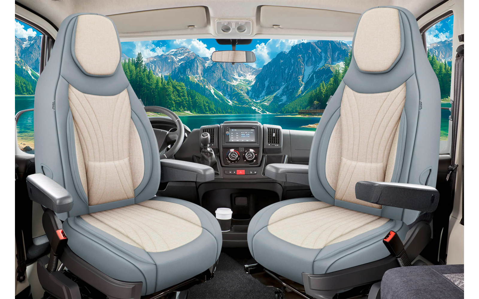 Zwei drehbare Vordersitze in einer Fahrerkabine mit Armlehnen und Kopfstützen, Lenkrad, Armaturenbrett mit Mittelkonsole und Becherhalter; durch die Windschutzscheibe Berge, See, Nadelbäume und blauer Himmel