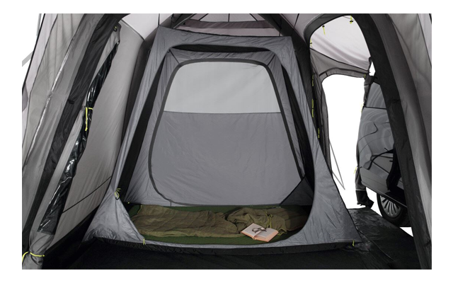 Interior de una tienda con una entrada abierta y una colchoneta con un libro encima