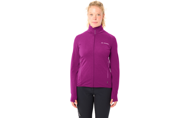 Person steht frontal, trägt violette Reißverschlussjacke mit hohem Kragen und Daumenlöchern, kleines Logo auf linker Brust, schwarze Hose, blonde Haare zu einem lockeren Dutt gebunden