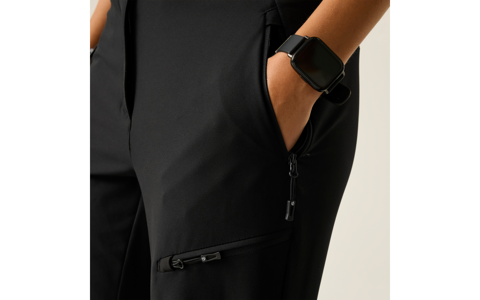 Zwarte broek met ritszakken aan de zijkant, hand in de zak, smartwatch om de pols