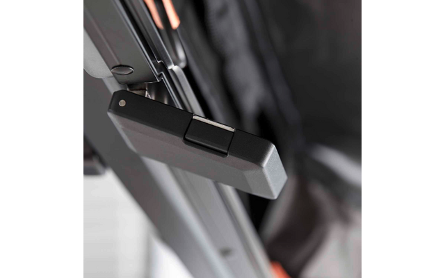 Nahaufnahme eines schwarzen Kunststoffverschlusses an einem Metallrahmen, im Hintergrund schwarzer Stoff