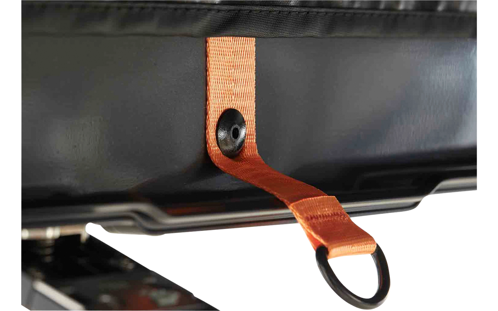 Oranger Stoffgurt durch eine schwarze Öse geführt, am Ende ein schwarzer Metallring; glänzende schwarze Oberfläche im Hintergrund; links unten ein Teil eines schwarzen Kunststoffteils sichtbar