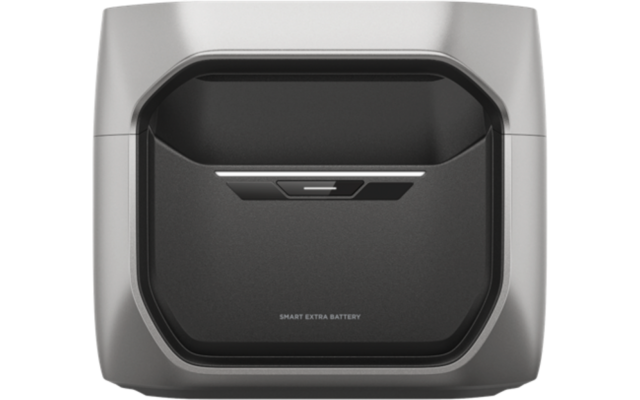 Silbergraues Gerät mit abgerundeten Ecken und dunkler, vertiefter Mittelpartie; vorne schmaler horizontaler Schlitz und Schriftzug "SMART EXTRA BATTERY"