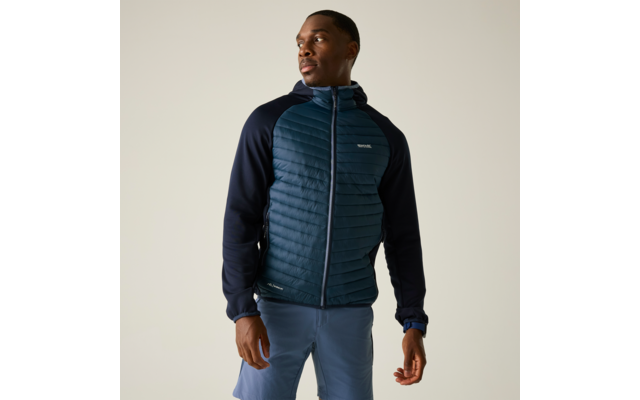 Stehender Mann in gesteppter blauer Kapuzenjacke und blauen Shorts, Blick nach rechts