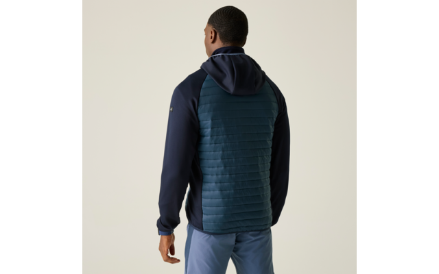 Person von hinten in dunkelblauer Kapuzenjacke mit gestepptem petrolfarbenem Rückenteil und hellblauen Hosen vor hellem Hintergrund