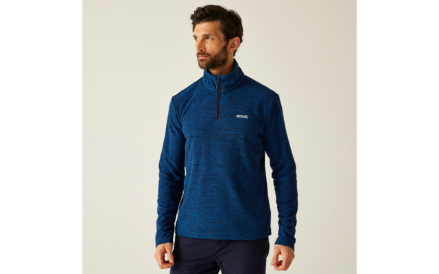 Ein mann mit einem blauen pullover vor einem weißen hintergrund