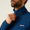 Ein Mann zieht den Reißverschluss seines blauen Fleece-Pullovers hoch