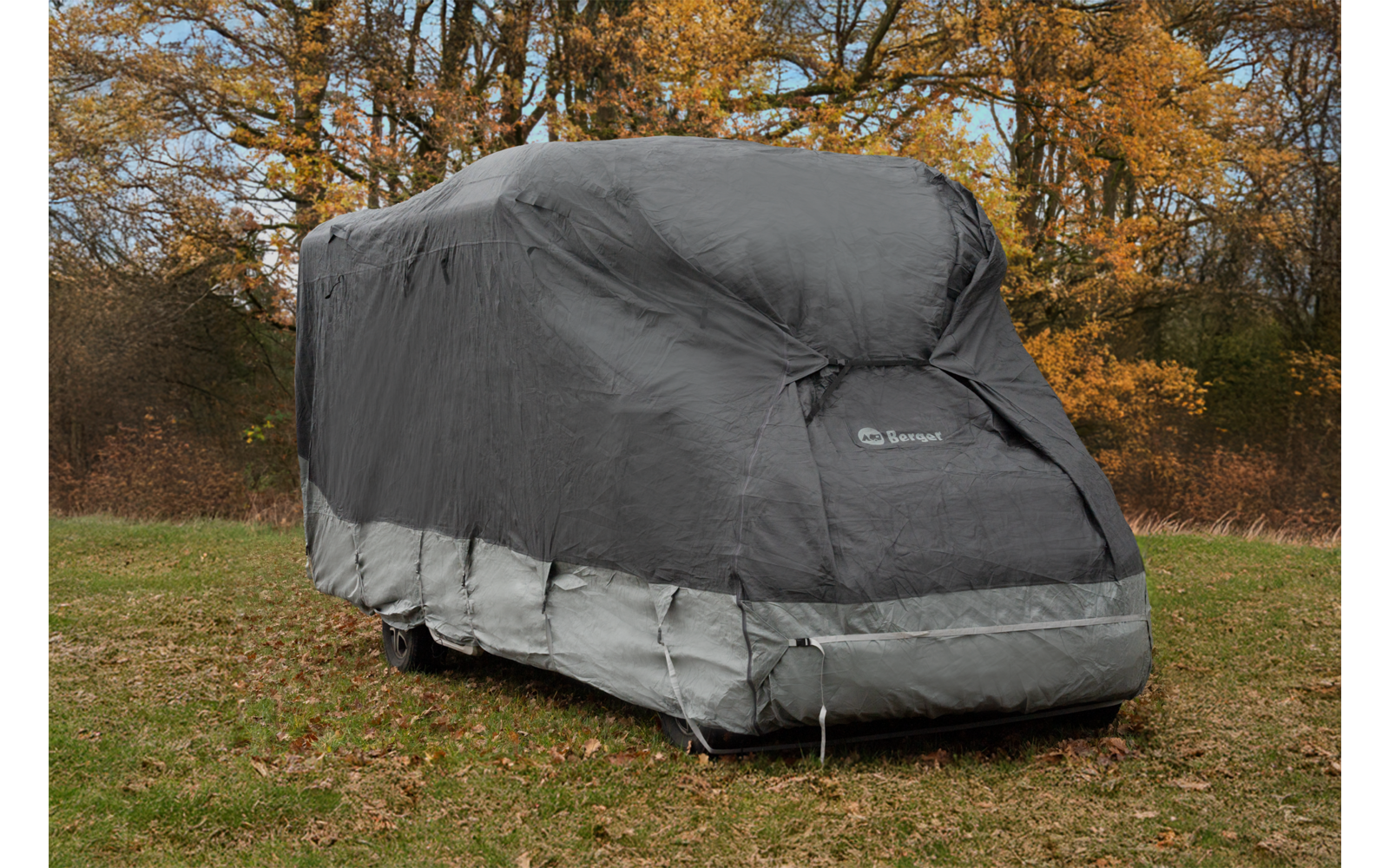 Large rectangular object on wheels fully covered by a gray protective cover; wheels and bottom edge visible
