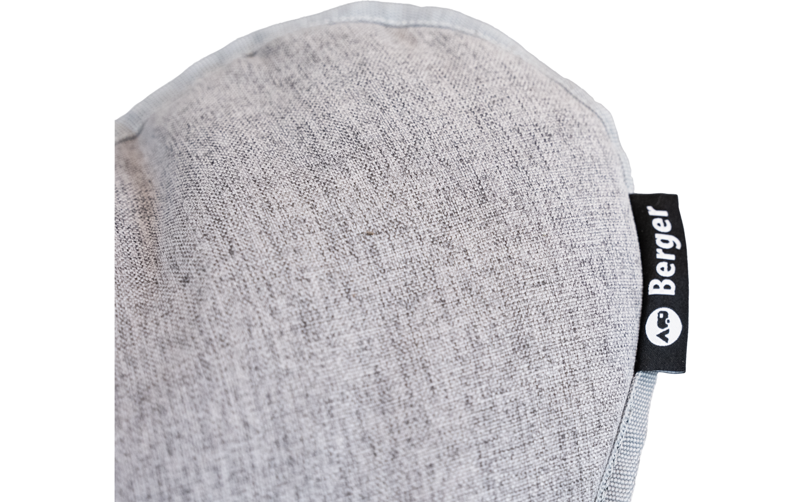 Runde hellgraue Stofffläche mit sichtbarer Naht am abgerundeten Rand; rechts ein schwarzes Textiletikett mit weißer Aufschrift Berger und kleinem weißen Symbol