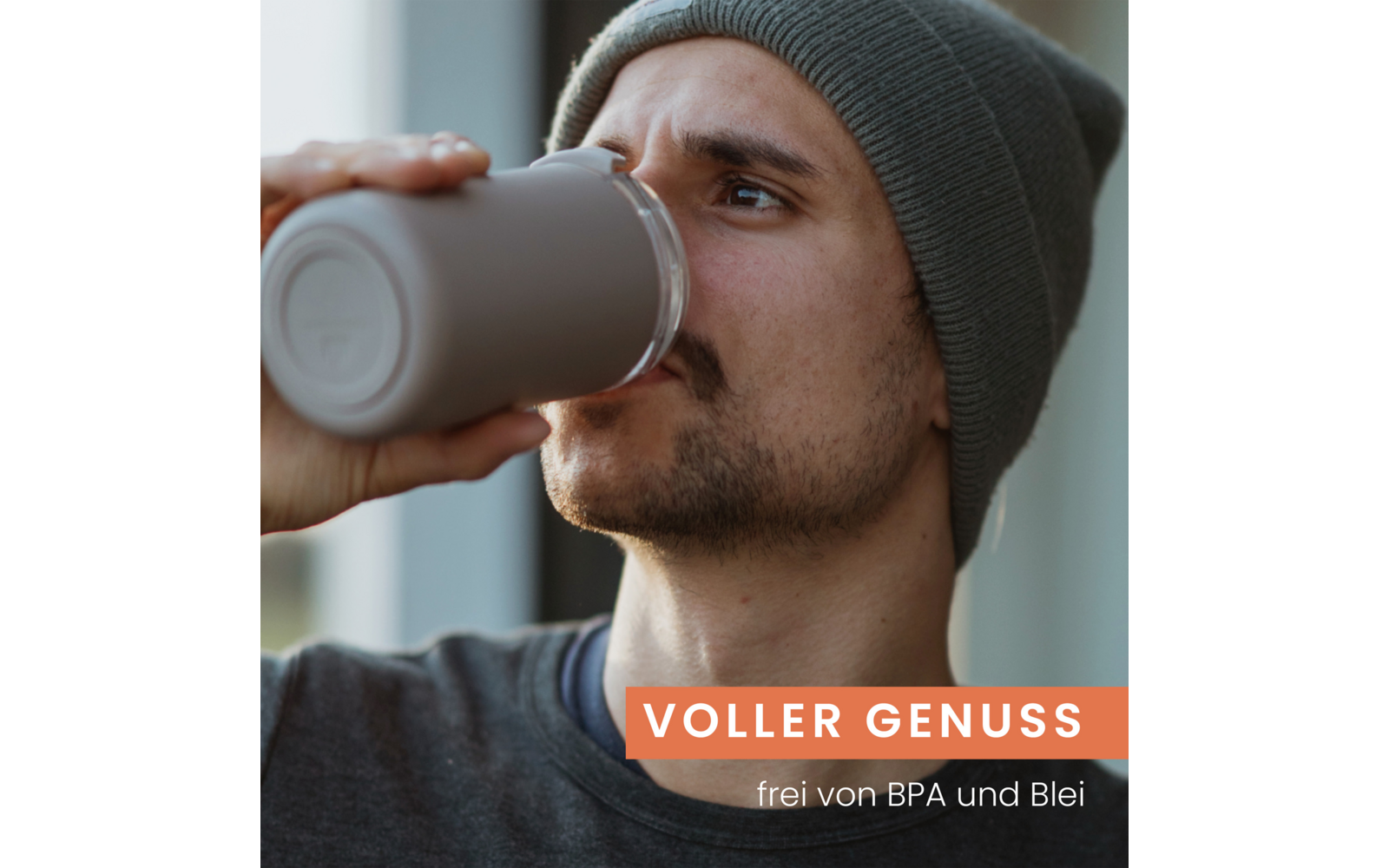 Nahaufnahme eines Mannes mit Strickmütze und Bart, der aus einem Thermobecher trinkt; orangefarbener Banner mit weißem Text 'VOLLER GENUSS' und kleinerem weißem Text 'frei von BPA und Blei'