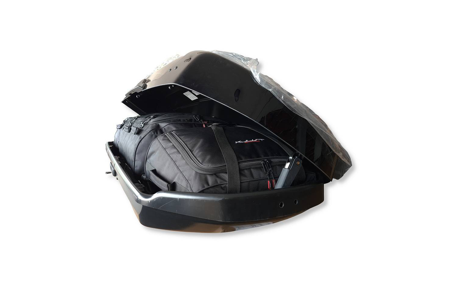 Coffre de toit noir ouvert avec un sac de voyage noir et des sangles à l'intérieur