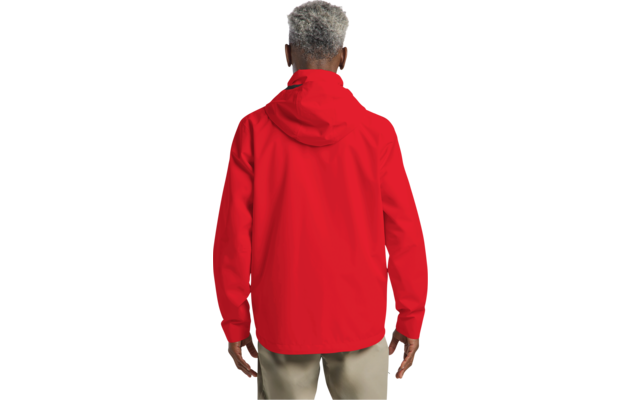 Person von hinten, rote Kapuzenjacke, hellbeige Hose, kurzes graues Haar, Hände seitlich sichtbar