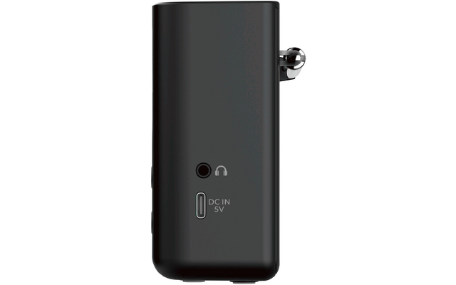 Schwarzes, aufrecht stehendes rechteckiges Gerät mit abgerundeten Kanten; rechts ein eingeklappter Metallstecker; vorne ein runder Anschluss mit Kopfhörersymbol und darunter ein rechteckiger Anschluss mit der Beschriftung 'DC IN 5V'