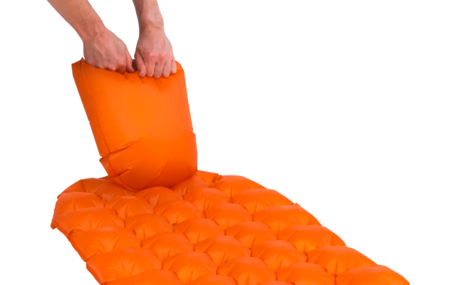 Handen die een oranje opgeblazen luchtkussen op een ondergrond leggen