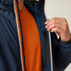 Oberkörper einer Person mit dunkelblauer, halb geöffneter Jacke; oranges T‑Shirt sichtbar; rechte Hand hält die Jacke geöffnet; Innentasche mit Reißverschluss sichtbar