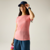 Vrouw in roze T-shirt en donkerblauwe pet, houdt een roze drinkfles vast, draagt blauwe shorts en een polshorloge, effen lichte achtergrond