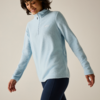 Persona con pile azzurro chiaro con mezza cerniera e leggings blu scuro, sorridente e con lo sguardo rivolto verso il basso