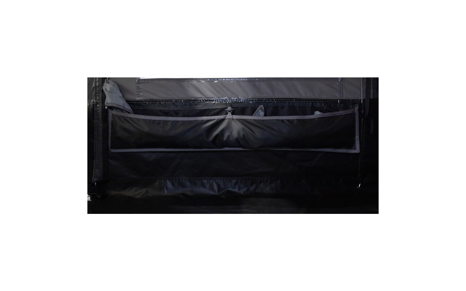 Dunkles Zeltinnere mit großer Stofftasche mit Reißverschluss an der Innenwand