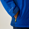 Blauer Jackenärmel mit Hand in seitlicher Reißverschlusstasche, gelber Reißverschluss-Anhänger, Aufdruck 'ISOTEX 10000' auf dem Ärmel, heller Hintergrund
