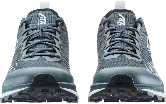 Zwei graublaue Sportschuhe, Frontalansicht, Schnürsenkel sichtbar, weißes Symbol auf den Zungen, profilierte Sohlen sichtbar