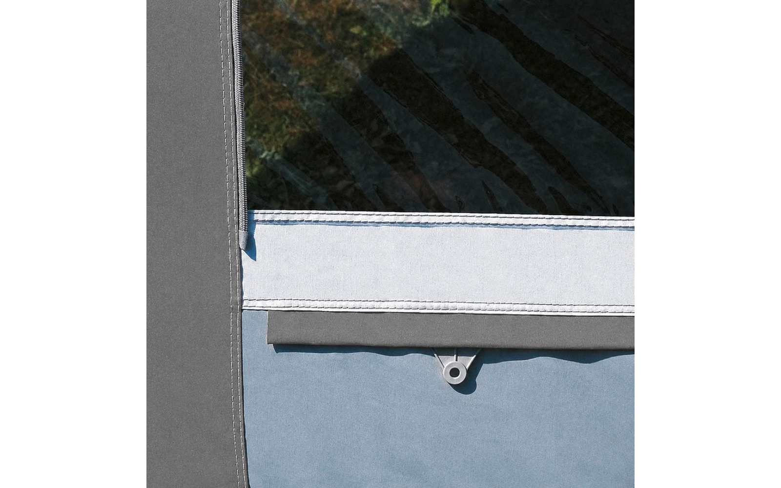 Close-up van grijs en lichtblauw textiel met een witte, gestikte rand, een transparant venster rechtsboven en een klein kunststof oogje in het midden onderaan