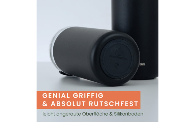 Zwei matte schwarze zylindrische Trinkbehälter auf hellgrauem Hintergrund; einer liegt auf der Seite und zeigt den runden Boden mit sichtbarem Logo, der andere steht teilweise im Hintergrund; orangenes Banner mit weißer und grüner deutscher Schrift