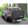 Grijze SUV vanaf achter-links, zwarte transportbox op de trekhaak met opschrift 'EUFAB' en kenteken 'TRANSPORTBOX', achterlichten, oprit, huis met glazen gevel en bomen op de achtergrond