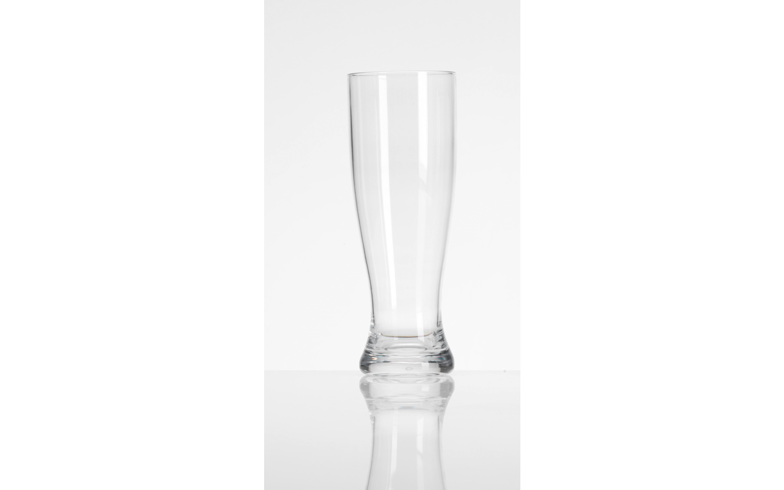 Verre haut et transparent vide sur une surface réfléchissante, fond blanc