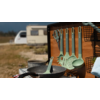 Camping-Küche mit Kochtöpfen, Pfannen und Küchenutensilien vor Wohnwagen