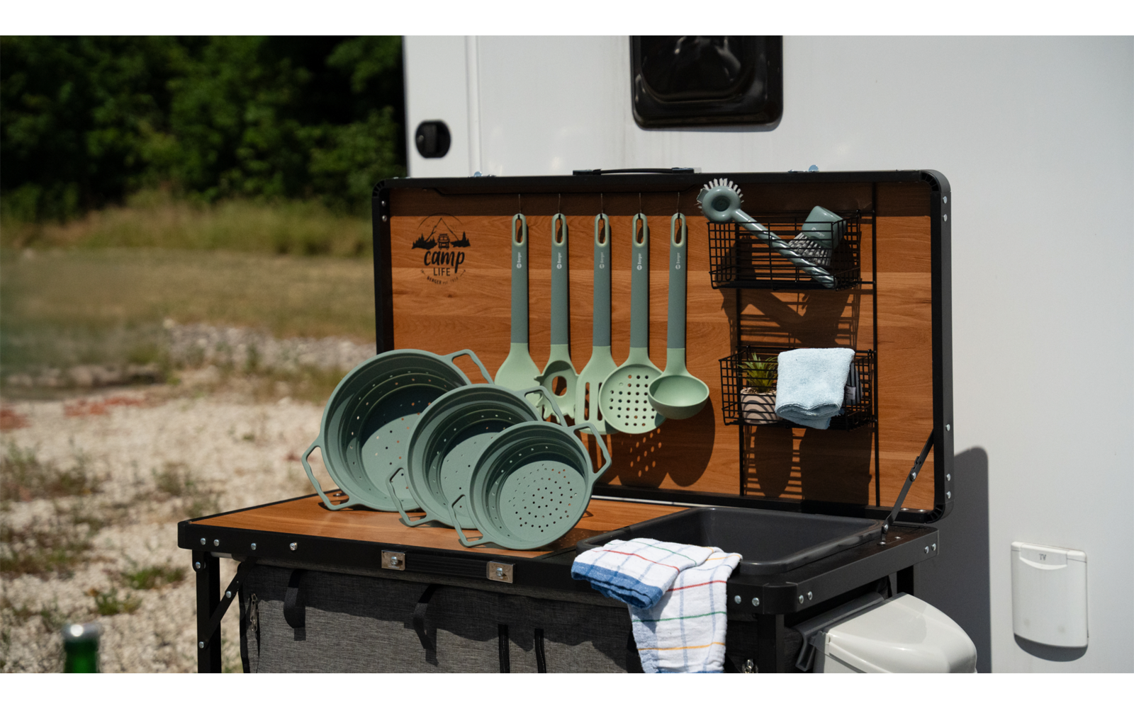 Campinggeschirr und Besteck vor einem Wohnmobil auf einem Klapptisch