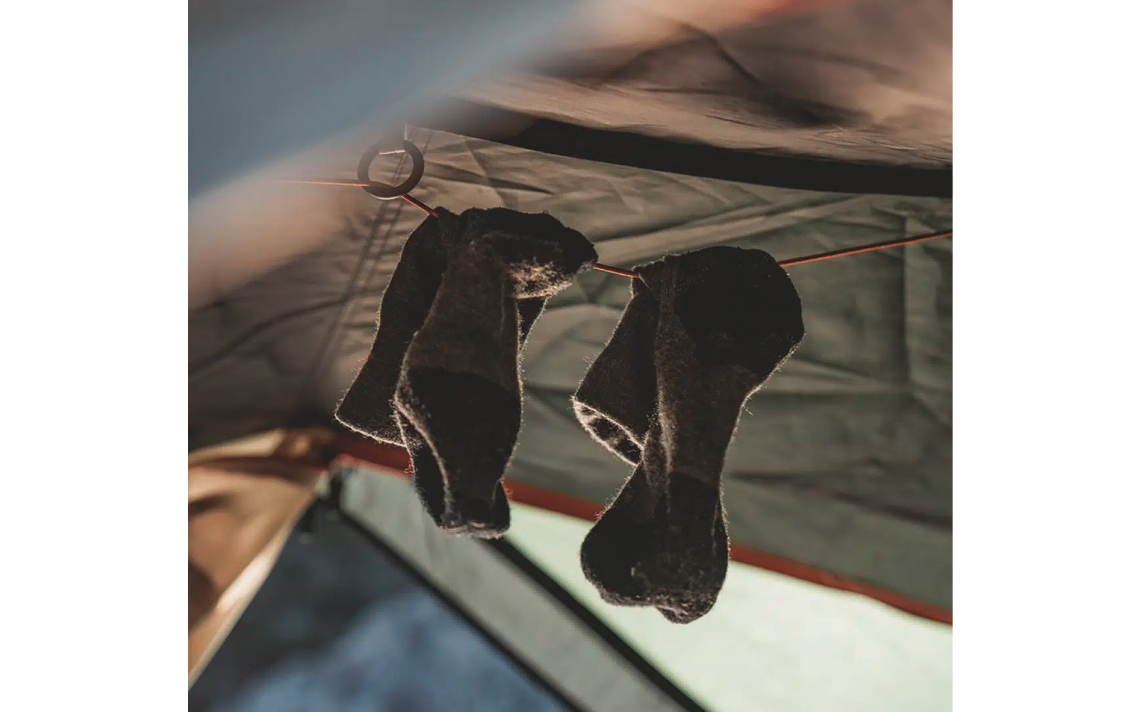 Zwei hängende, gebrauchte Socken unter einem Zelt