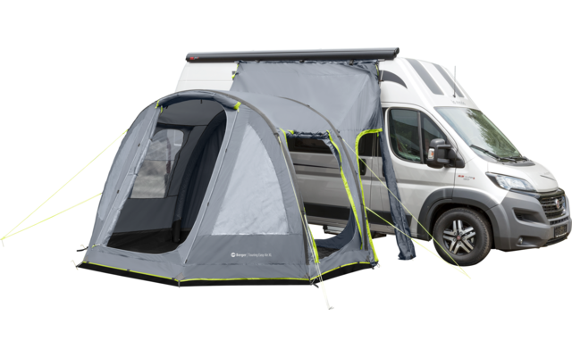 Ein weißer Wohnmobil mit einem grauen und grünen Vorzelt, das an der Seite befestigt ist