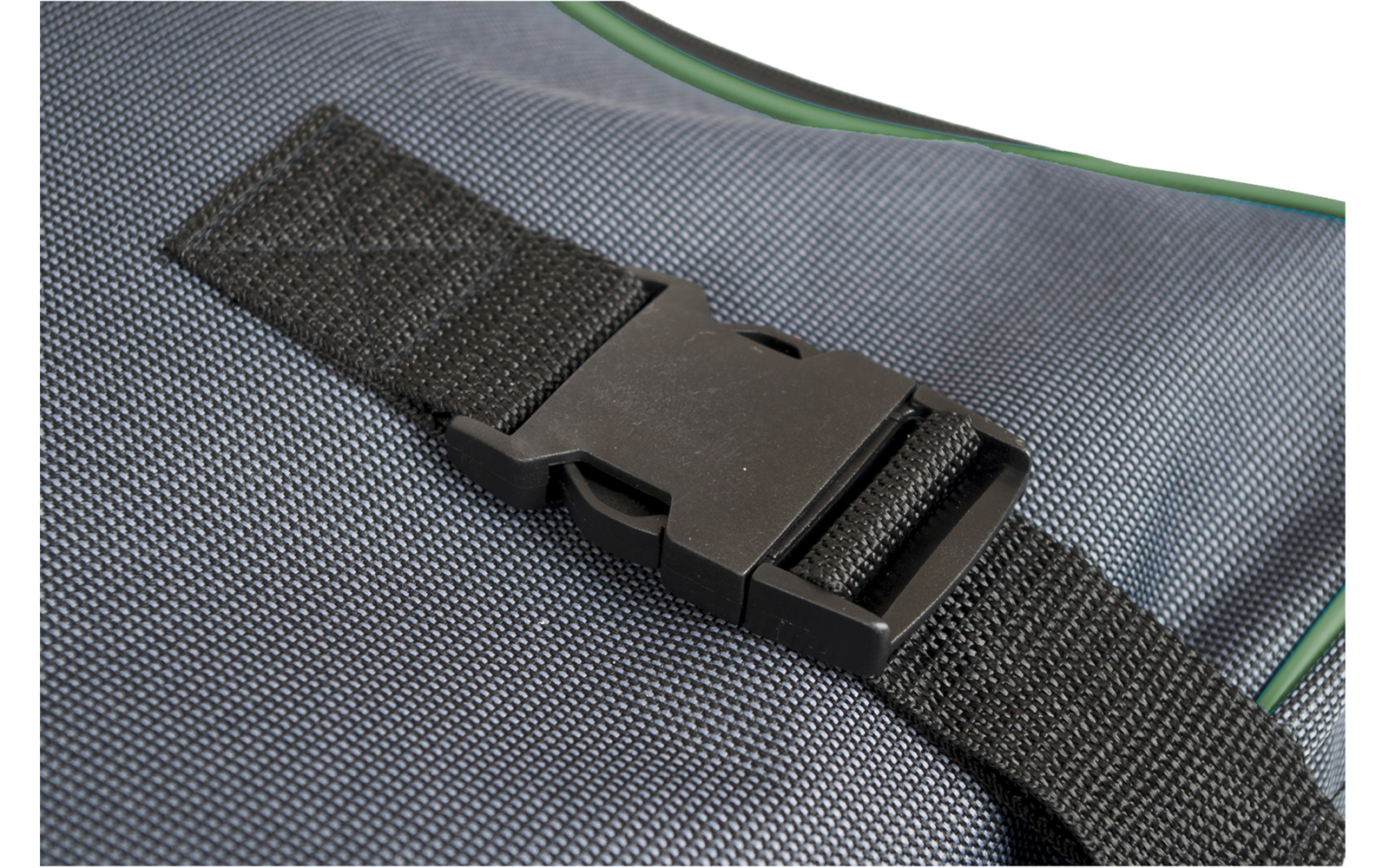 Boucle en plastique noire sur une sangle noire, à côté d'une zone rectangulaire de Velcro, sur un tissu gris texturé avec un bord vert