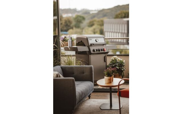 Grill im Freien auf einer Terrasse mit Pflanzen und Möbeln