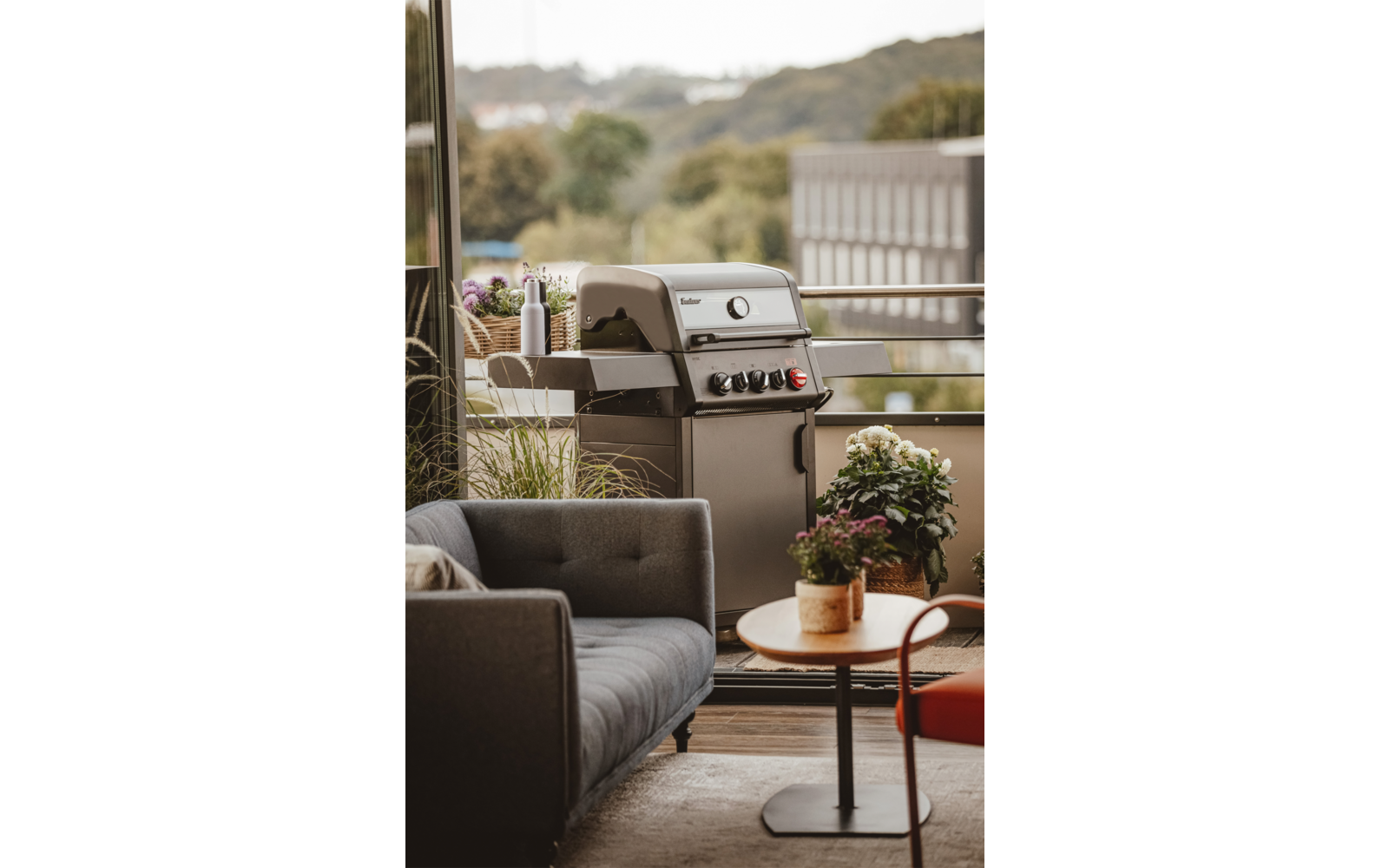 Grill im Freien auf einer Terrasse mit Pflanzen und Möbeln