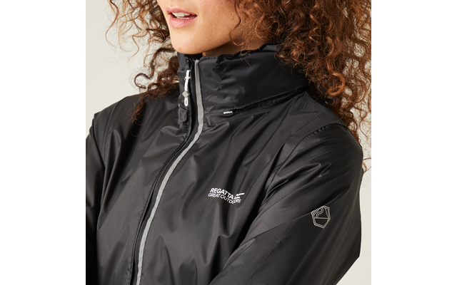 Primo piano della parte inferiore del viso e del busto di una persona con capelli ricci, indossa un giubbotto antipioggia nero lucido con collo alto, striscia di cerniera argentata, logo bianco "Regatta Great Outdoors" sul petto e piccolo emblema sulla manica