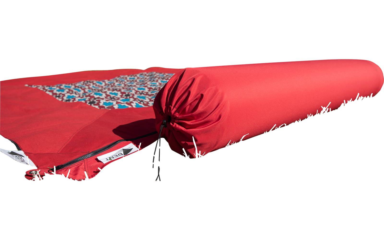 Red rolled-up yoga mat lying on grass
