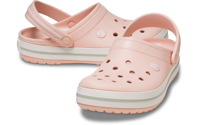 Zwei hellrosa Kunststoff‑Clogs mit Fersenriemen und Löchern, weiße Sohle mit grünem Streifen