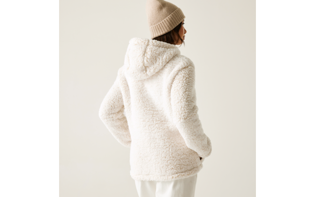Frau von hinten mit weißer, kapuzenbekleideter Teddyjacke und beiger Mütze