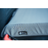 Gray padded cushion with black fabric label "Berger", on a dark textured surface; red plastic piece at bottom left