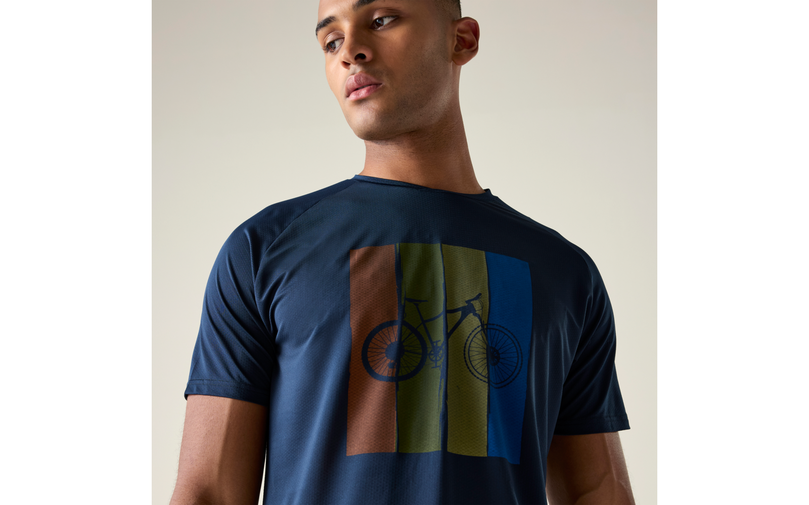 Person trägt dunkelblaues T-Shirt mit Fahrradgrafik über vier vertikalen Farbstreifen (braun, grün, oliv, blau)